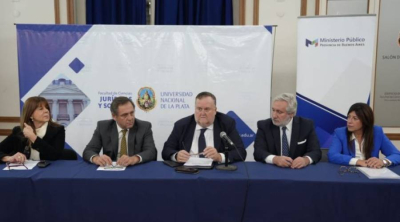 Cinco autoridades sentadas en la mesa de apertura de la Jornada sobre Discapacidad y Salud Mental en la UNLP. De izquierda a derecha: Dra. Mabel Cardoni, Dr. Claudio Santagati, Dr. Julio Conte-Grand (Procurador General) hablando al micr&oacute;fono, Dr. Daniel Soria y Dra. Rosario S&aacute;nchez.