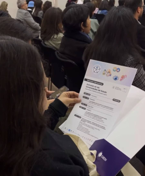 Asistente al Seminario Internacional sosteniendo el folleto impreso del programa con el logo del CUECH.